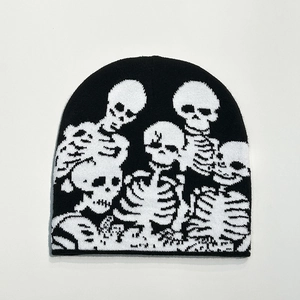 Detail of black knitted beanie with white skull pattern and high-quality fabric texture