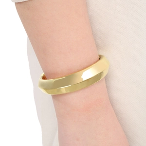 Détail du bracelet manchette doré 18k en acier avec bords géométriques facettés