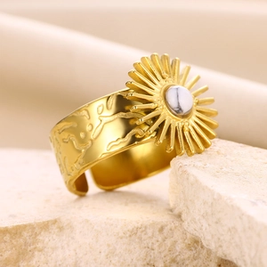 Detailed close-up of a vintage sunburst gold titanium ring with a white turquoise stone