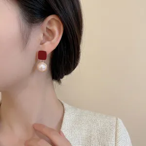 Elegant red square studs with white pearl drops on model in a soft vintage style