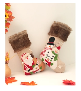 Detail of Christmas burlap stockings with plush fur cuff and 3D Santa embroidery