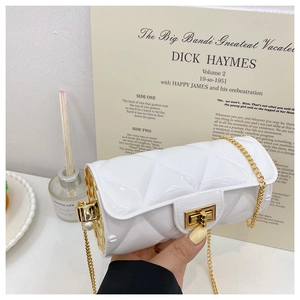 Detail of white quilted cylindrical jelly bag with gold chain strap and pearl accents