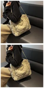 Detail of light beige quilted tote bag featuring a diamond pattern and leather strap