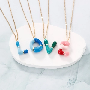 Colorful LOVE letter pendant necklace set with gold chain on white stone base