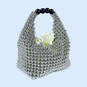 Detail of silver beaded pillow bag with black handle beads and white satin lining