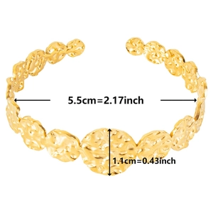 Detailed view of C-shaped gold bangle with 5.5cm inner diameter and 1.1cm width dimensions