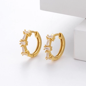 Macro shot of gold-plated silver huggie hoop earrings set with rectangular zirconias