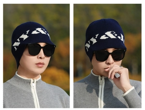 Detail of navy knit beanie with ear flaps and white NY graphic pattern for winter sports