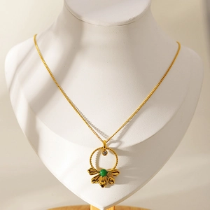 Gold stainless steel clover pendant necklace with green gemstone and zircon on a neck model