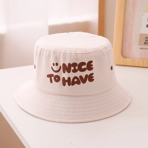 Détail de la broderie NICE TO HAVE et du smiley sur le chapeau bob en coton blanc cassé