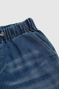 Macro view of mid-rise elastic waistband with drawstring on blue denim pants
