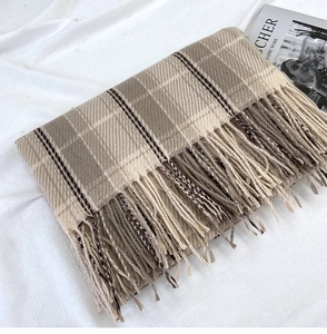 Detailed view of British style khaki plaid scarf featuring handmade fringe and soft texture
