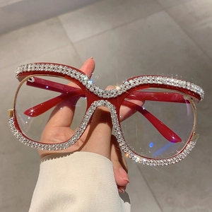 Macro detail of red oversized frames with sparkling rhinestone accents and gold metal trim