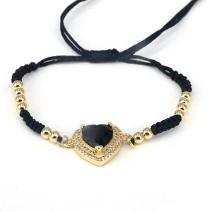 Woven heart bracelet with gold beads and black heart stone on a clean white background