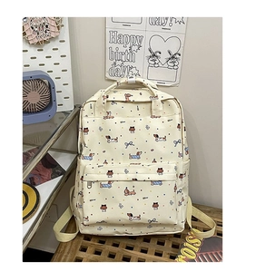 Detail of cream backpack with dachshund dog illustrations and a front zipper pocket