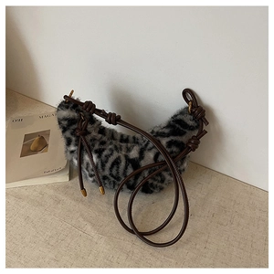 Détail d'un sac demi-lune en peluche léopard avec bandoulière nouée marron élégante
