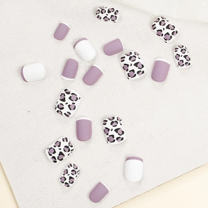 Faux ongles mats violet lavande et imprimé léopard présentés sur un plateau blanc