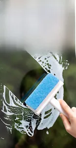 Macro detail of the 2-in-1 window cleaning brush scraping foam off a glass surface