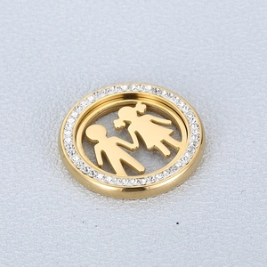 Gros plan du pendentif doré avec bordure en cristal et motif garçon fille