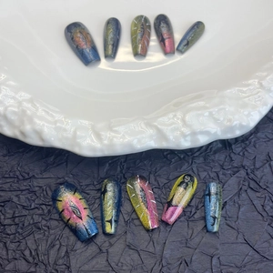 Cat eye press-on nails with dark aesthetic star patterns on long trapezoid tips