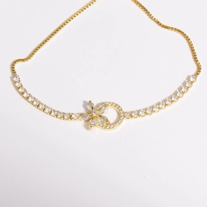 Détail du bracelet fleur plaqué or avec pierres en zircone et chaîne à mailles carrées
