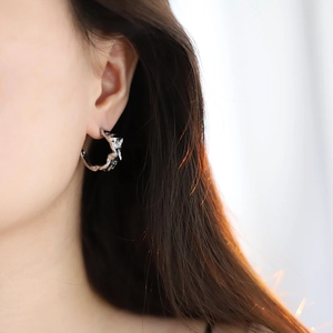 Irregular silver hoop earrings with lava texture design shown on model for fashion