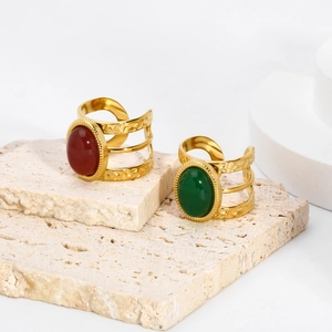 Detail of three-layer hammered gold rings with oval red and green natural stones