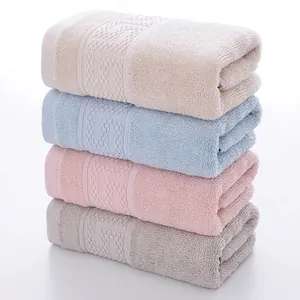 Set of four cotton towels in beige, blue, pink and grey with soft looped texture