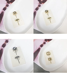 Detailed view of minimalist gold and silver geometric metal hair clips on a ceramic plate