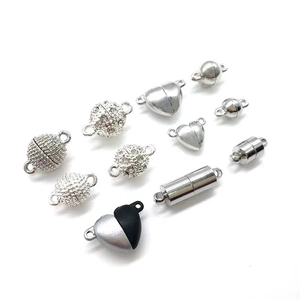 Various magnetic jewelry clasps in heart and sphere shapes with rhinestones on white