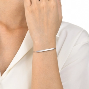 Close-up of a minimalist silver stainless steel curved bar bracelet on a woman wrist