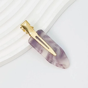 Detail shot of purple marble pattern acetate hair clip with golden metal spring fastener