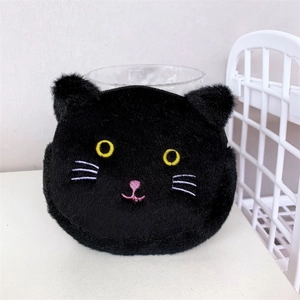 Close-up of black plush cat coin purse with detailed yellow eye embroidery and soft texture