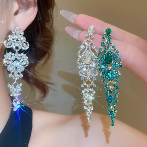 Macro detail of silver long tassel earrings with sparkling green zircon crystals