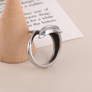 Close-up of a silver dolphin ring with a blue sapphire eye on a wooden display stand