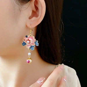 Detail of vintage flower earrings with pearls and enamel hanging on model's ear
