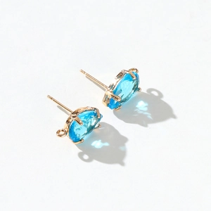 Detail of 14k gold plated stud earrings featuring faceted sea blue cubic zirconia stones