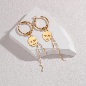 Gold hoop earrings with skull charms and white beaded long tassels on white stone