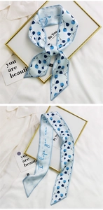 Detail of silk hair ribbon with blue floral print and script text on white shirt