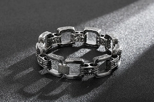 Détail d'un bracelet punk vintage en argent avec gravures géométriques et maillons en métal