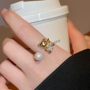 Detailed view of adjustable gold-plated ring with crystal bear and white pearl accent