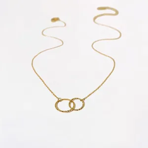 Minimalist double interlocking circle necklace in gold finish with hammered texture on chains