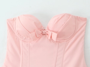 Detail van een roze bustier in Franse stijl met decoratieve strik en korsetconstructie