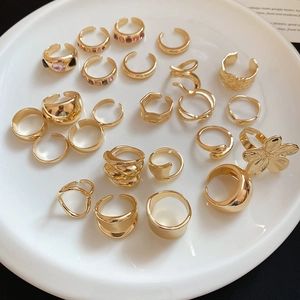 Close-up of geometric irregular gold ring set with purple stones on white ceramic tray