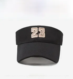 Front view of black breathable woven sun visor featuring beige embroidered number 23 detail