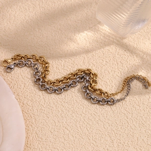 Detail of 14K gold and silver chunky link chains with lobster clasps on warm background
