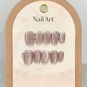 Handmade cat-eye press-on nails in dusty rose with glitter and silver rhinestone accents