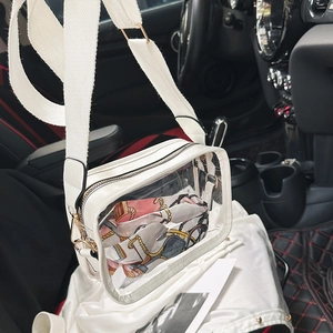 Macro shot of transparent PVC crossbody bag with wide white strap and printed silk scarf