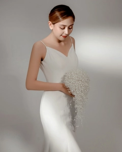 Detailed view of elegant bridal pearl bouquet paired with white fishtail wedding dress