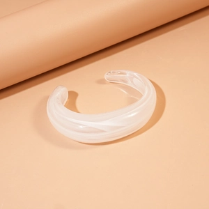 Detail shot of white acrylic open bangle with marble texture and polished resin finish